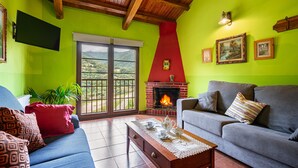 A living room with a fireplace, a sofa, a coffee table, and a television.