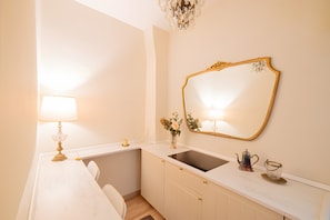 Une salle de bain avec un lavabo, un miroir et un lustre.