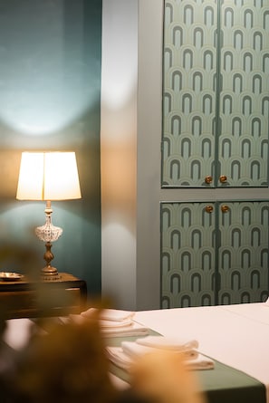 Une chambre d’hôtel avec un lit, une lampe de chevet et un mur orné d’armoires décoratives.