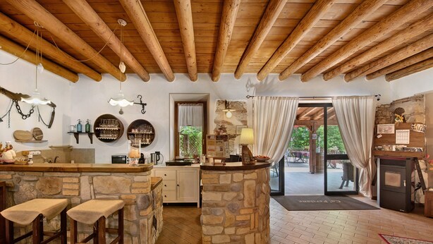 Una cocina rústica con encimeras de piedra, taburetes de madera y una barra de piedra.