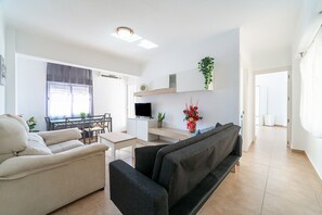 Un salon moderne avec un canapé, une table à manger et un téléviseur.
