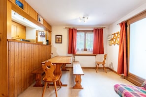 A wooden interior with a dining table, benches, and a sofa. - Apartment 'La Bévéria 5' with Private Terrace and Shared Garden (Pralognan-la-Vanoise)