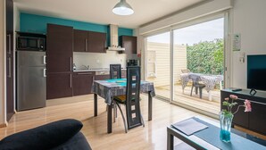 Cozinha moderna com área de refeições, TV de tela plana e vista para o exterior.