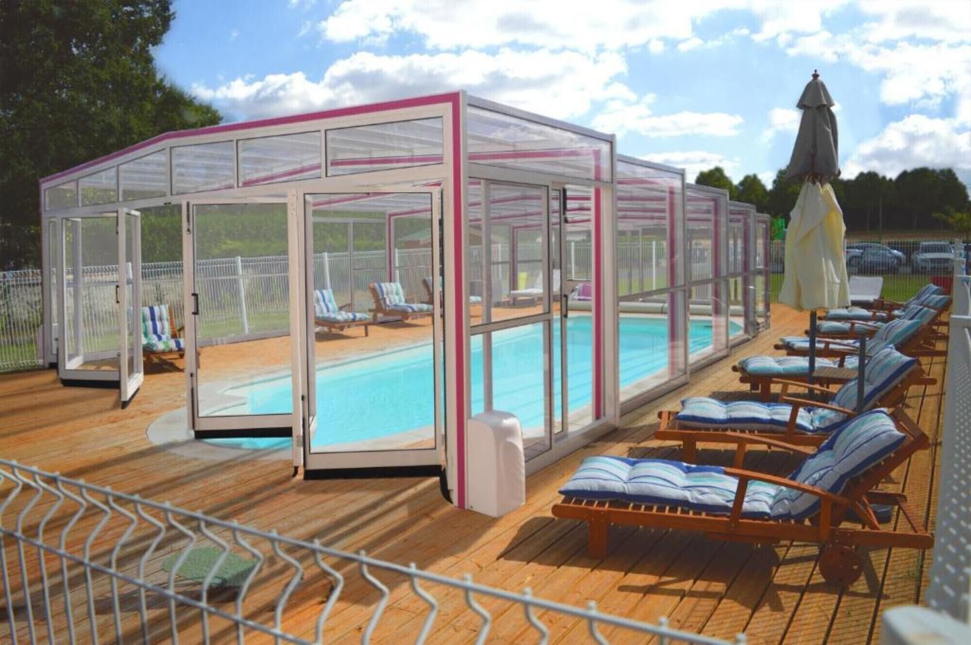Area piscina coperta con sedie a sdraio e un pergolato.