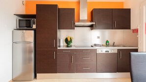 Een moderne keuken met donkere houten kastjes, een roestvrijstalen magnetron en een vaatwasser.