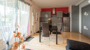 A modern kitchen with grey cabinets, a microwave, and a refrigerator. - Apartment 'Le Clos Du Champ De L'Amour - Royan' with Private Pool, Wi-Fi & Air Conditioning (Saint-Simon-de-Bordes)