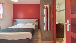 A modern hotel room with a large bed, a red accent wall, and a shower area. - Apartment 'Le Clos Du Champ De L'Amour - Talmont' with Private Pool, Wi-Fi & AC (Saint-Simon-de-Bordes)