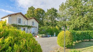 A stone building with a gravel driveway, surrounded by lush greenery and a well-maintained garden. - Apartment 'Le Clos Du Champ De L'Amour - Talmont' with Private Pool, Wi-Fi & AC (Saint-Simon-de-Bordes)