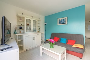 A living room with a sofa, a coffee table, a TV, and a cabinet.