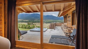 A wooden deck with a hot tub, lounge chairs, and a view of mountains. - Chalet 'Isabella Lodge Pyrénées' with Lake View, Private Terrace and Wi-Fi (Bolquere Pyrenees 2000)