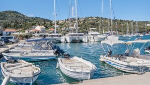 A marina with various boats docked, a hilly backdrop, and buildings in the distance. - Studio Apartment 'Vaso' with Mountain View, Wi-Fi and Air Conditioning (Nikiana)