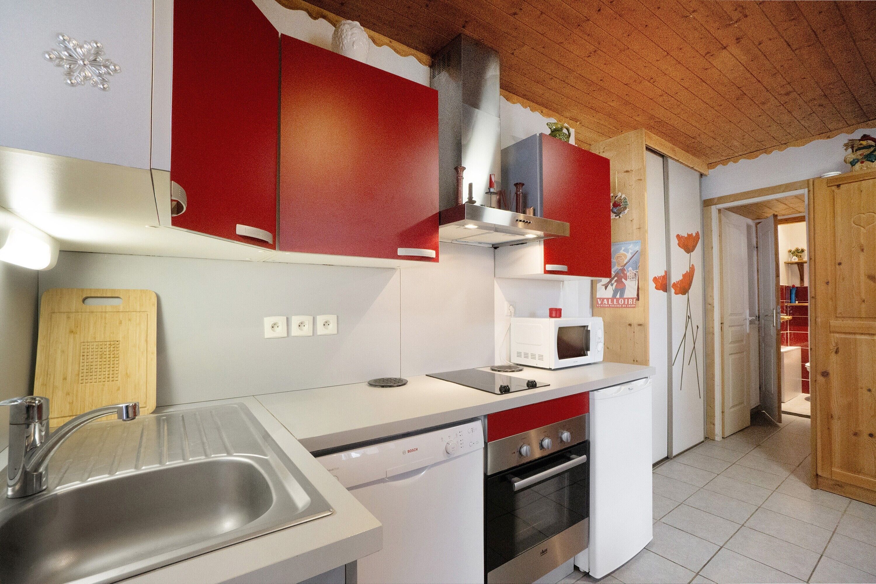 A kitchen with a sink, dishwasher, stove, and microwave.