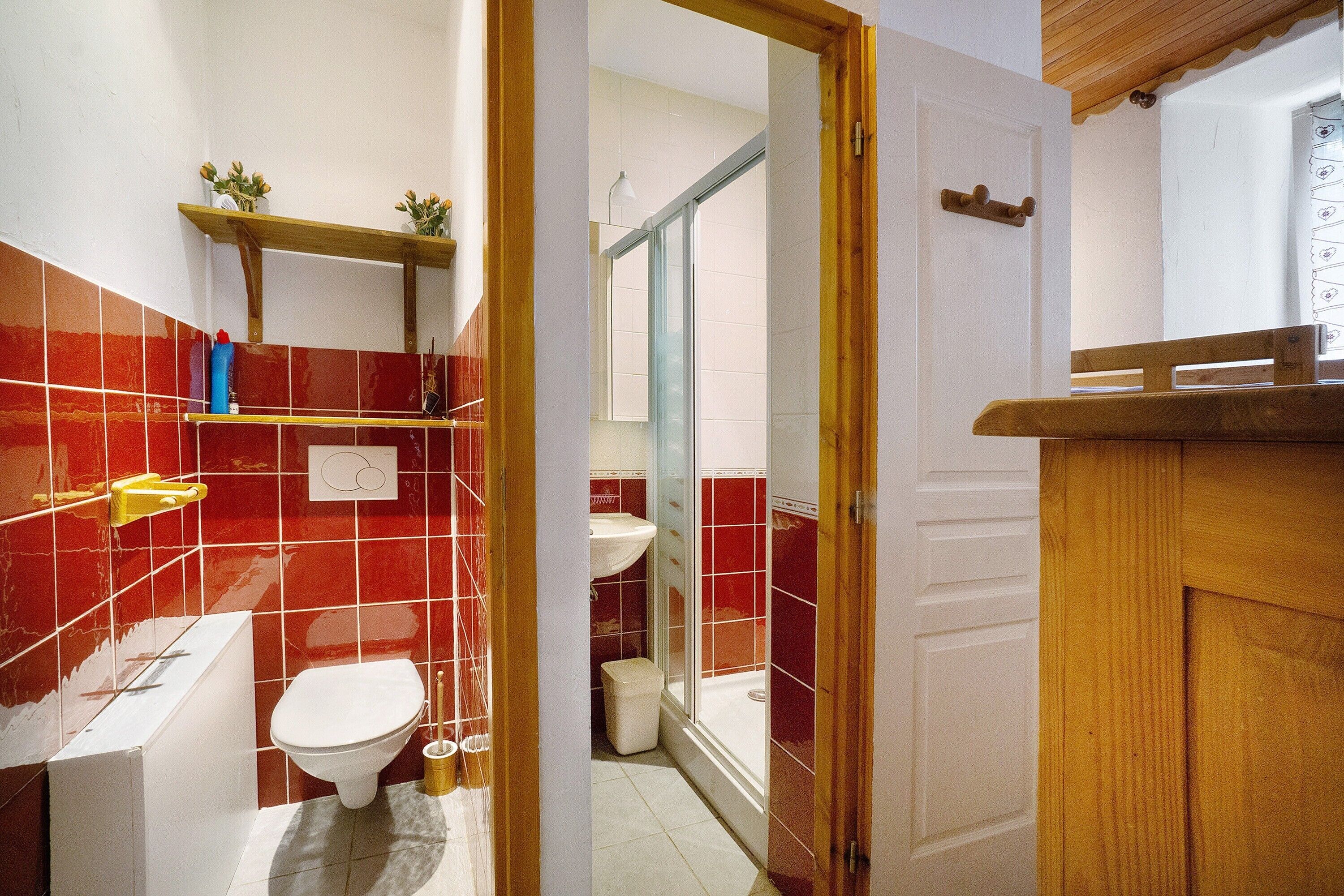 A bathroom with a toilet, sink, and shower area.