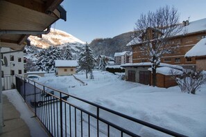 A snow-covered village with wooden buildings and a mountain backdrop. - Apartment 'Les Ecrins 3' with Mountain View (Valloire)