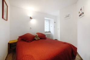 Une chambre à coucher avec un lit, une fenêtre et une porte.