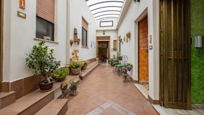 A corridor with a skylight, potted plants, and a green wall. - Room 'Appartamento 3 - Stanza 31' with Shared Terrace, Wi-Fi and Air Conditioning (Ficarra)