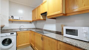 Fridge, microwave, coffee/tea maker, cookware/dishes/utensils