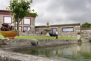 A stone building with a fountain, a large planter, and a small pool. - Quinta of Carvoeiras  'Casa Do Caseiro - T2' with Lake View, Wi-Fi and Air Conditioning (Vieira do Minho)
