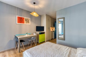 A bedroom with a bed, a desk with a chair, a television, and a mirror. - Studio with Terrace Steps from the Beach in La Grande Motte – Renovated 2026 (La Grande-Motte)