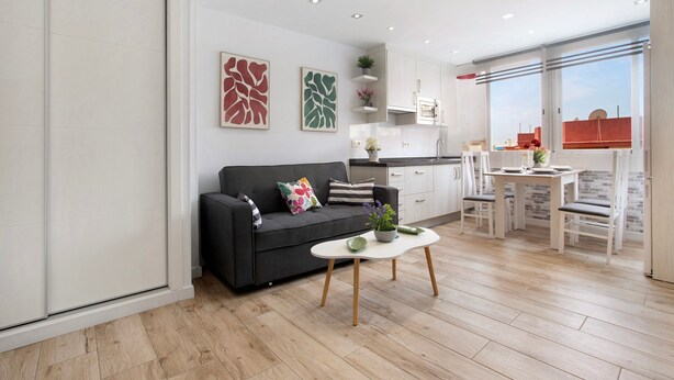 Una sala de estar moderna con un sofá, una mesa de centro y un comedor.