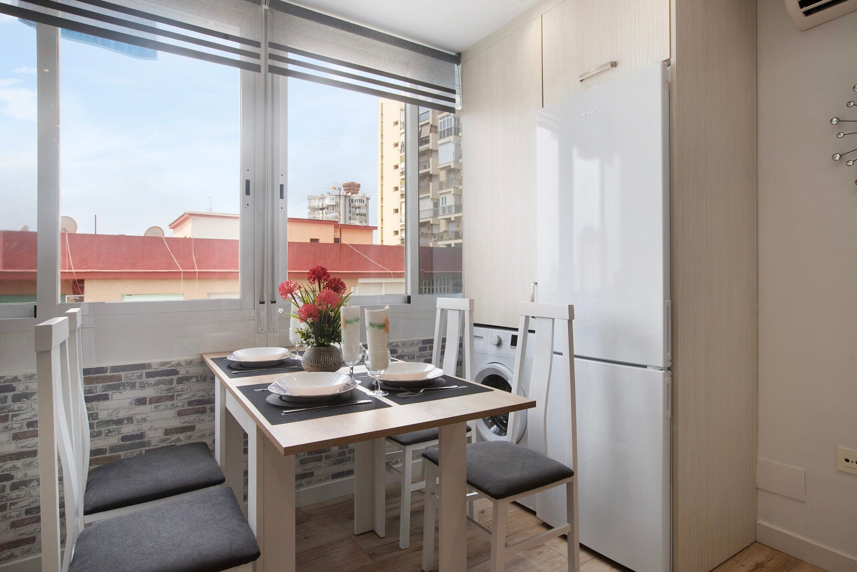 Cocina compacta con comedor, lavadora y refrigerador.