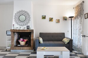 A living room with a fireplace, a sofa, a coffee table, and wall art.