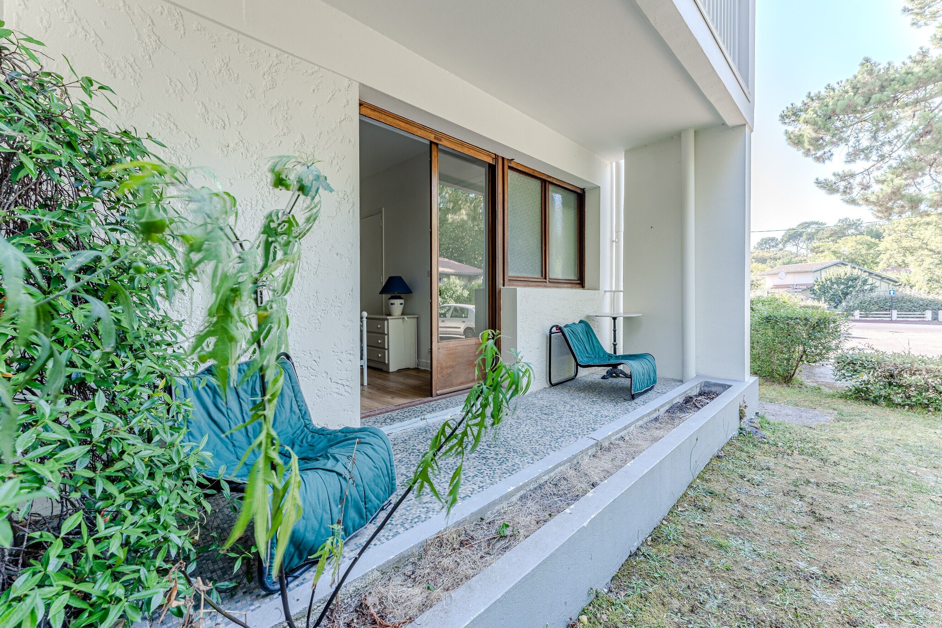 A modern building with a covered porch, a chair, and a table.