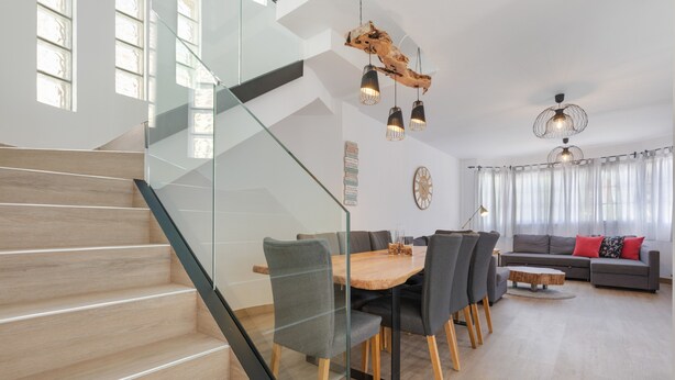 Un interior moderno con una escalera, comedor y sala de estar.