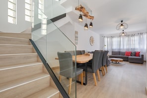 Un intérieur moderne comprenant un escalier, un coin repas et un salon.