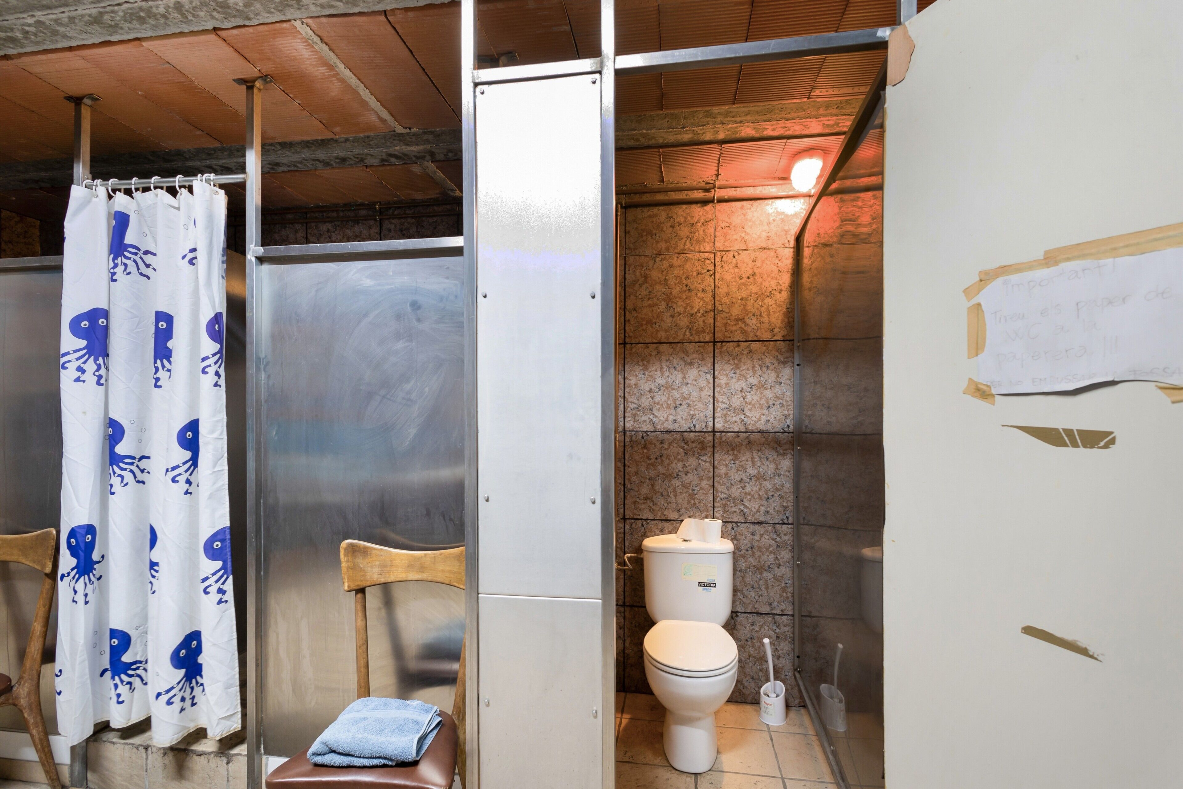 A bathroom with a shower curtain, a toilet, and a sink.