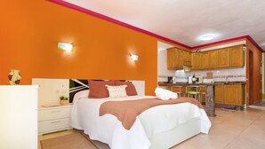 Een slaapkamer met een bed, nachtkastje en een klein plantje op het nachtkastje.