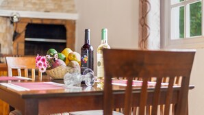 A dining table with chairs, a fireplace, and bottles of wine. - Vacation Apartment 'Teide' with Wi-Fi (Icod de los Vinos)