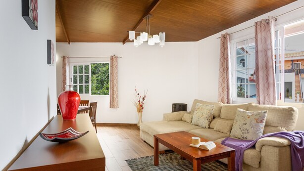 A living room with a sofa, a coffee table, a wooden ceiling, and a window with curtains. - Vacation Apartment 'Teide' with Wi-Fi (Icod de los Vinos)