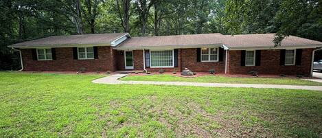 Stroll through the serene surroundings of this charming home, surrounded by lush trees and a beautifully manicured lawn.