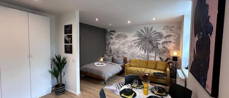 Un espace de vie moderne comprenant un lit, un canapé et un coin repas.