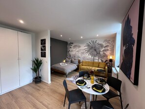 Ein stilvoller Wohnraum mit Bett, Sofa und Essbereich.