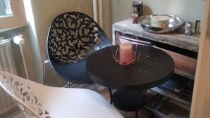 A small dining area with a round table, two chairs, and a decorative wall. - Cosy alternative Apartment (Berlin)