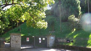 A gated entrance with a stone wall and metal gate, a stop sign, and a no parking sign. - Eva Apartament with Lake View in Baveno (Baveno)
