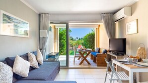 A modern living room with a sofa, TV, and dining area. - Les Marines de Gassin by Interhome (Gassin)