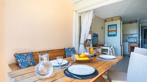 A wooden dining table set with plates, glasses, and a fruit basket. - Les Marines de Gassin by Interhome (Gassin)