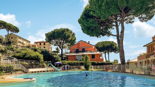 A swimming pool with a slide, surrounded by trees and buildings. - Amazing apartment in Camogli with WiFi (Camogli)