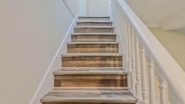 A staircase with wooden steps and white balusters. - Chic, Cozy & New! Great location, Street Parking with AC (Renton)