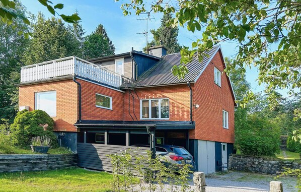A two-story house with a sloped roof, a balcony, and a garage.