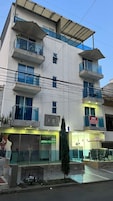 A multi-story hotel with balconies, a visible sign for a spa, and a small tree in the foreground.