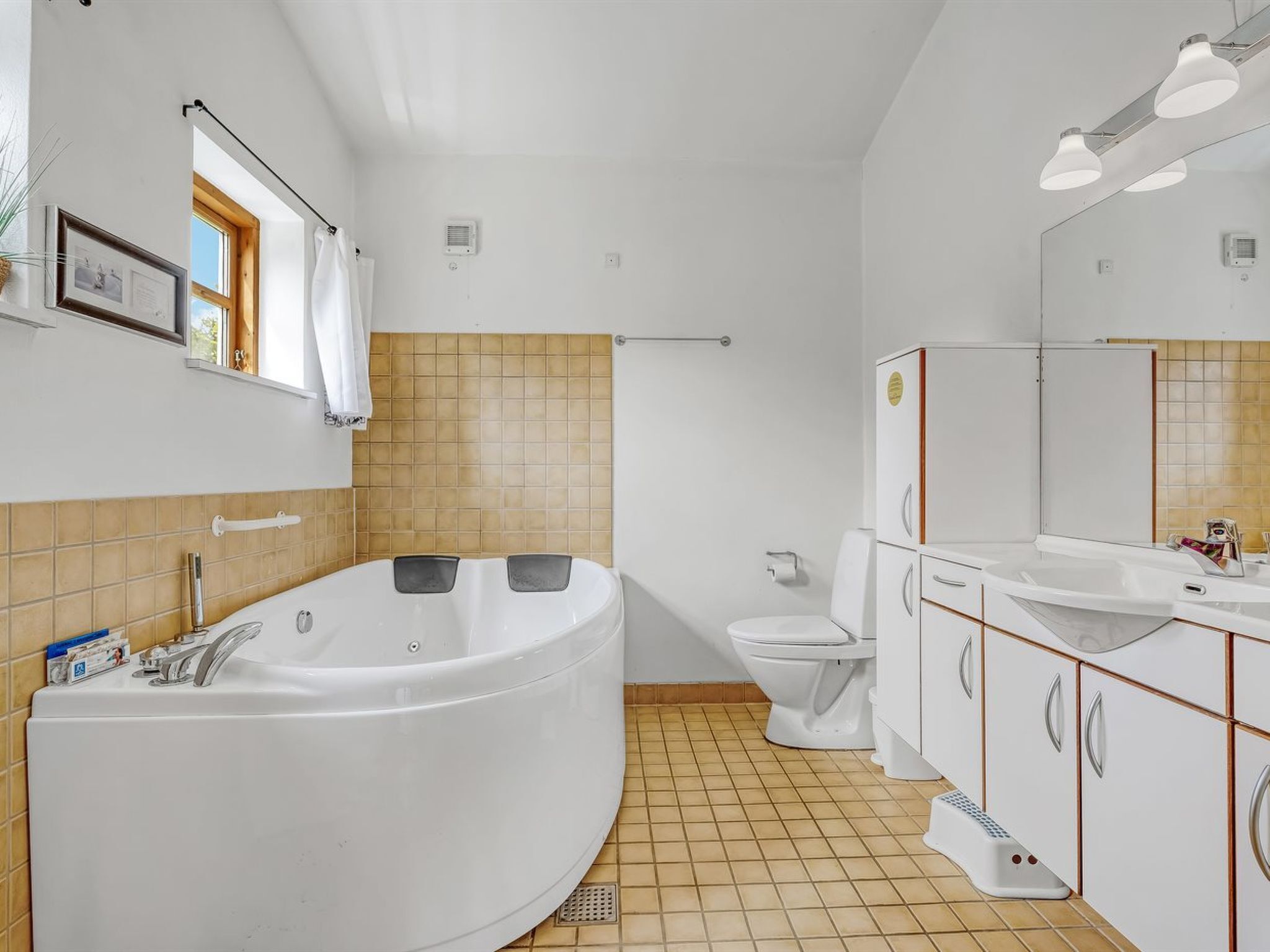 Een moderne badkamer met een groot bad, een toilet en een wastafel.