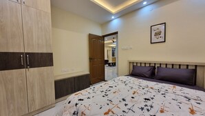 A bedroom with a bed, a wardrobe, and a door leading to another room. - Airport Inn  (Chennai)