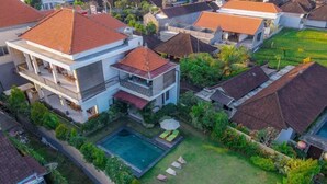 Un barrio residencial con varias casas, una piscina y un césped bien cuidado.