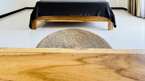 Un dormitorio con una cama de madera, dos lámparas colgantes y una pared decorada con diseños de palmeras.