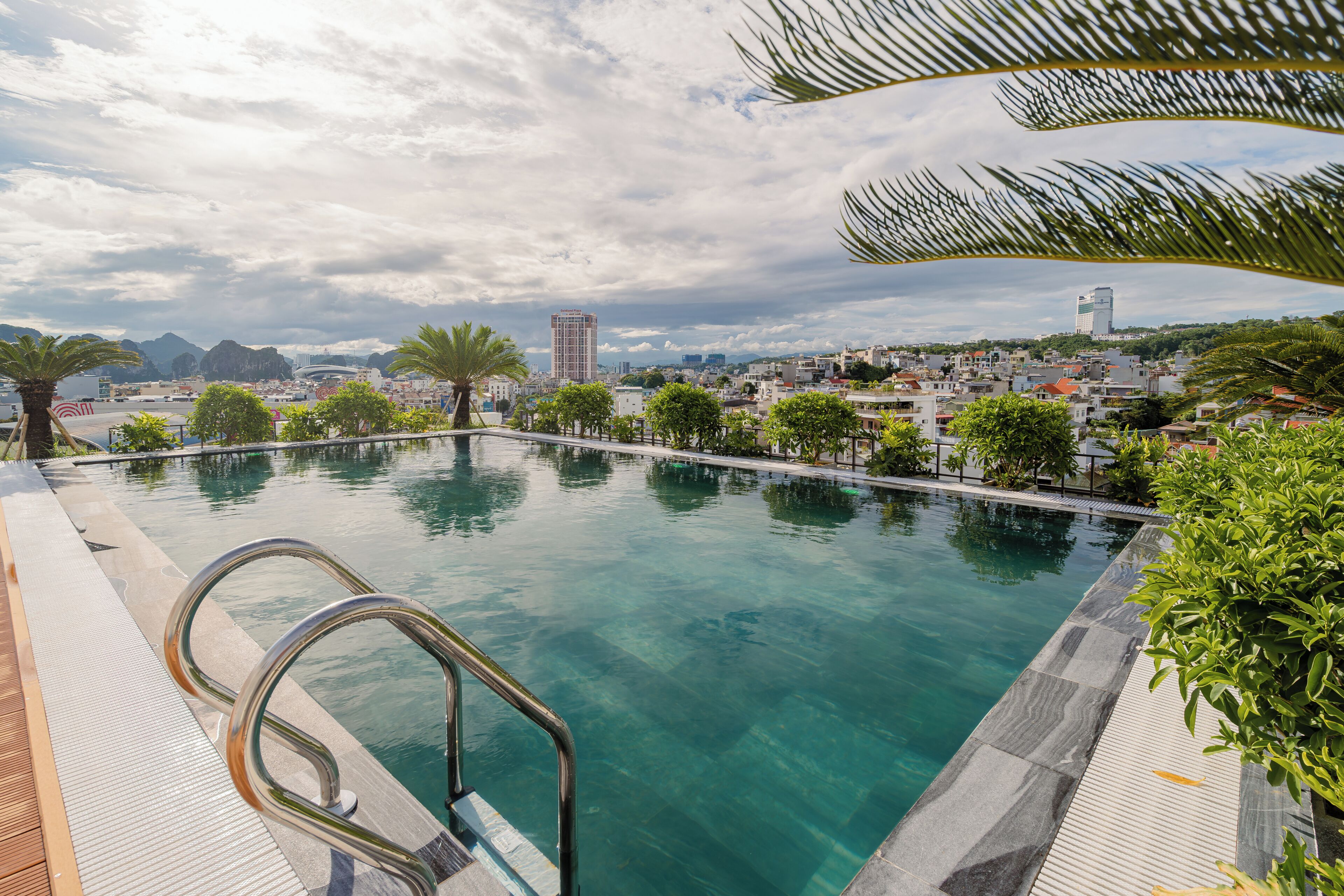 A swimming pool with a view of a cityscape, including a prominent building labeled 'Goldland Plaza.'