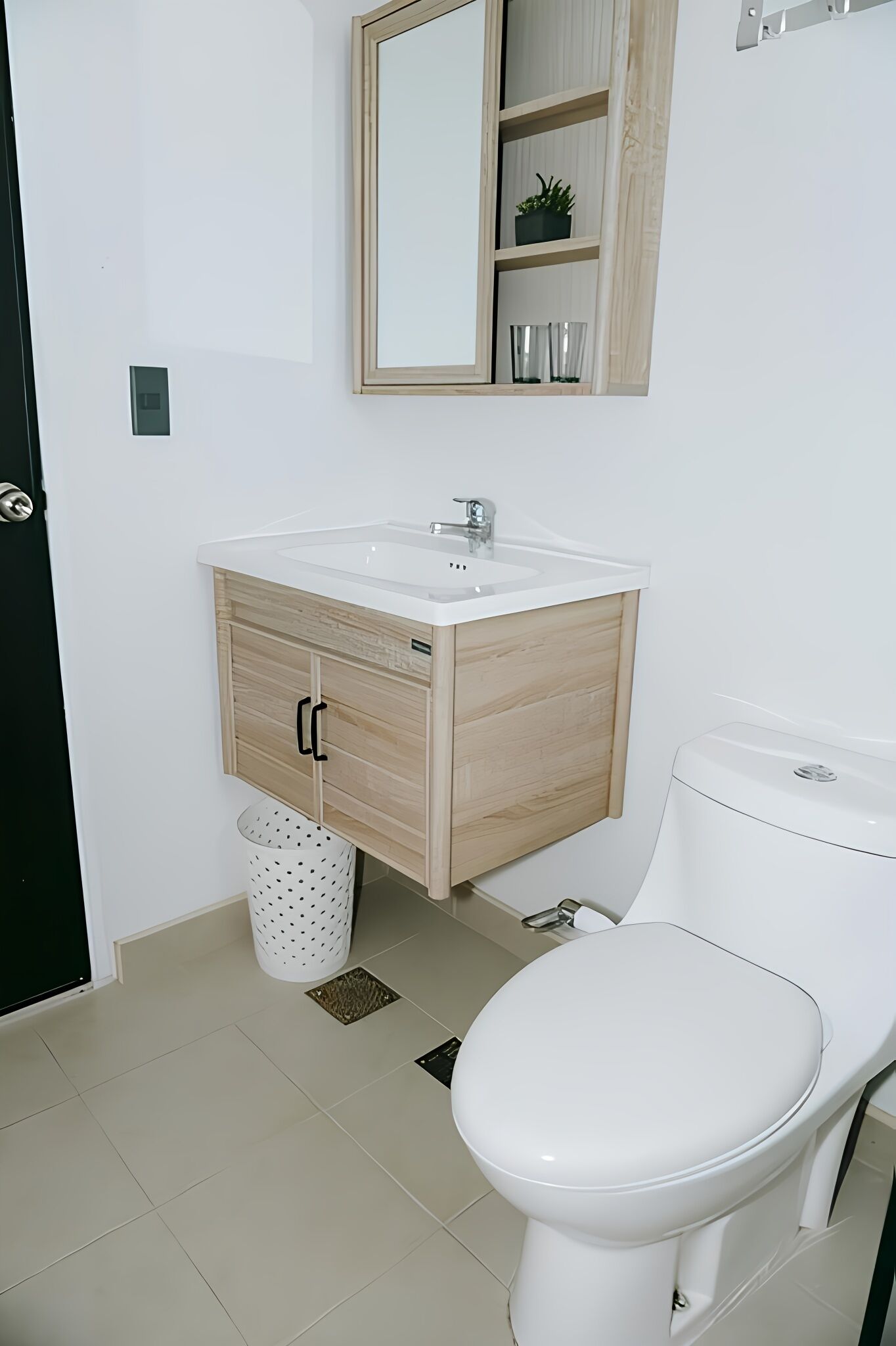 Ein Badezimmer mit einem weißen Waschbecken, einem Holzschrank und einer Toilette.